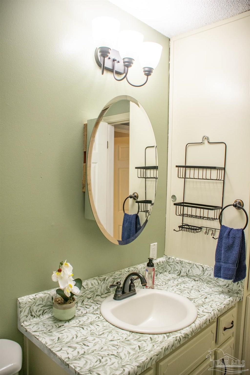 6514 Oakcrest Road Milton, FL 32570 - Photo 45 of 68 a bathroom with a sink and a mirror