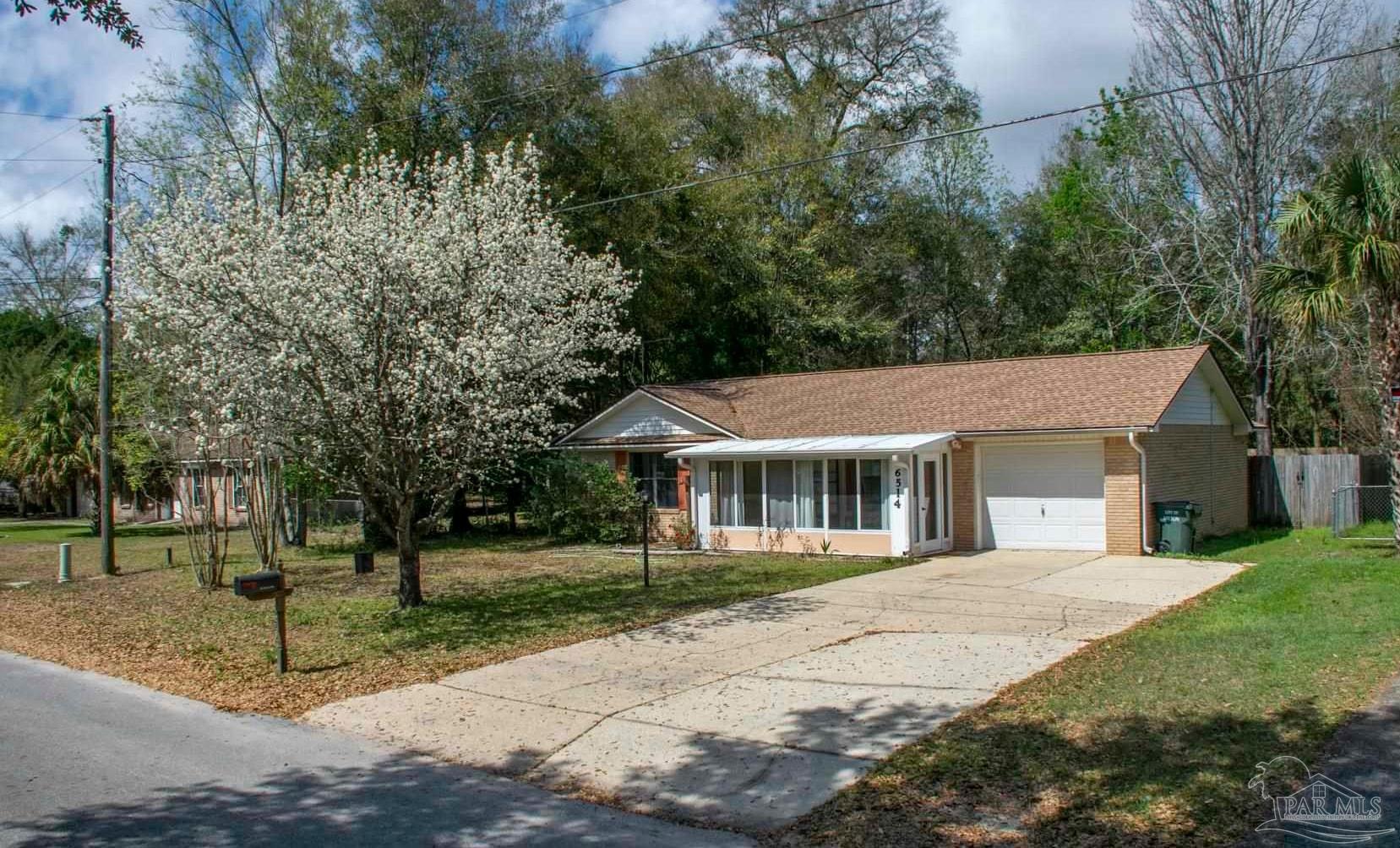 6514 Oakcrest Road Milton, FL 32570 - Photo 6 of 68 a view of a white house with a big yard and potted plants and trees