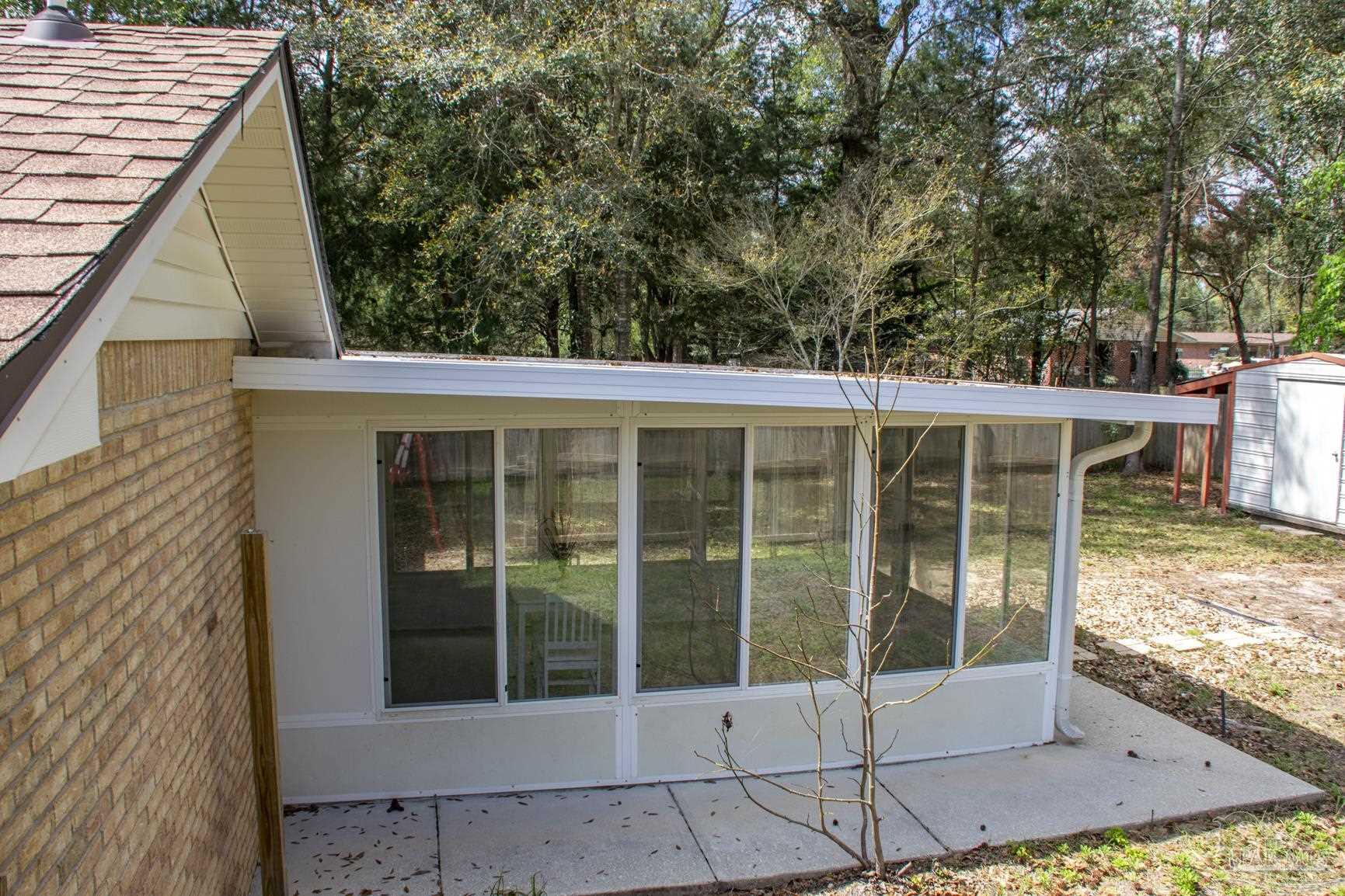 6514 Oakcrest Road Milton, FL 32570 - Photo 9 of 68 a view of a porch with a floor to ceiling window and wooden fence