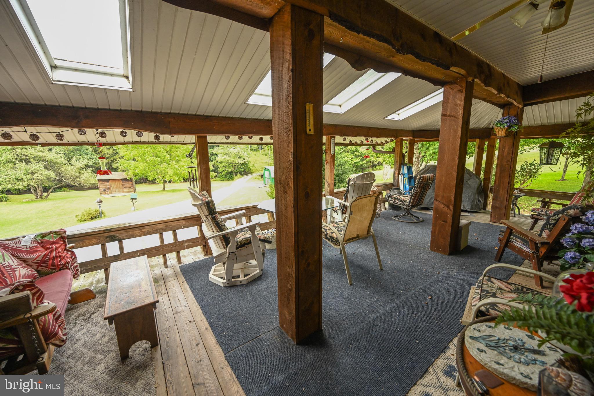 2527 Pigs Ear Road Grantsville, MD 21536 - Photo 27 of 94 a view of a patio with table and chairs potted plants with wooden floor and seating space