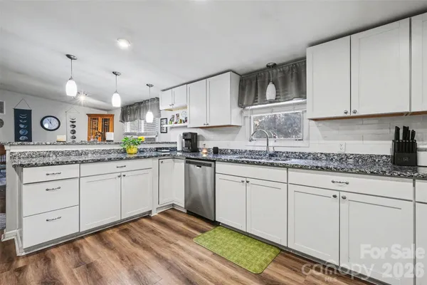 a kitchen with granite countertop white cabinets and white appliances