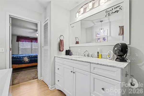 a en suite bathroom with a granite countertop sink and a mirror