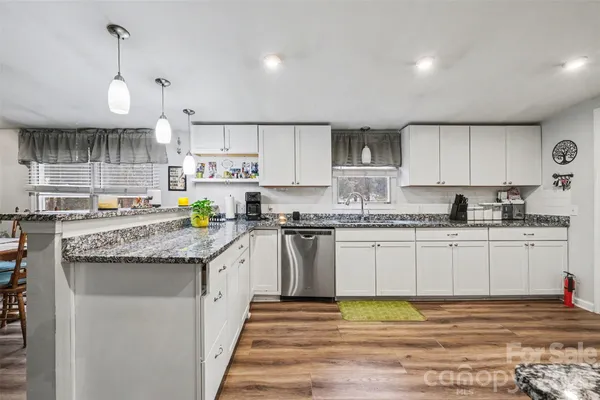 a kitchen with granite countertop a sink and cabinets