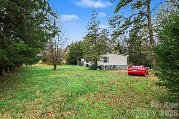 a front view of a house with yard and tree