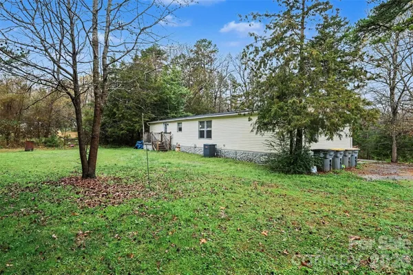 a view of a house with backyard and tree
