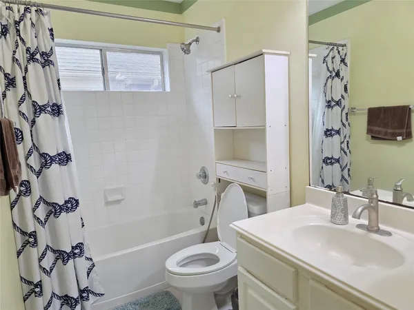 a bathroom with a granite countertop sink toilet a mirror and shower