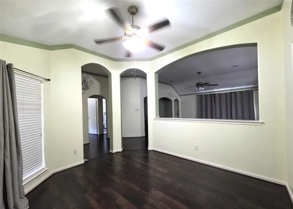 a view of a hallway with wooden floor and ceiling fan