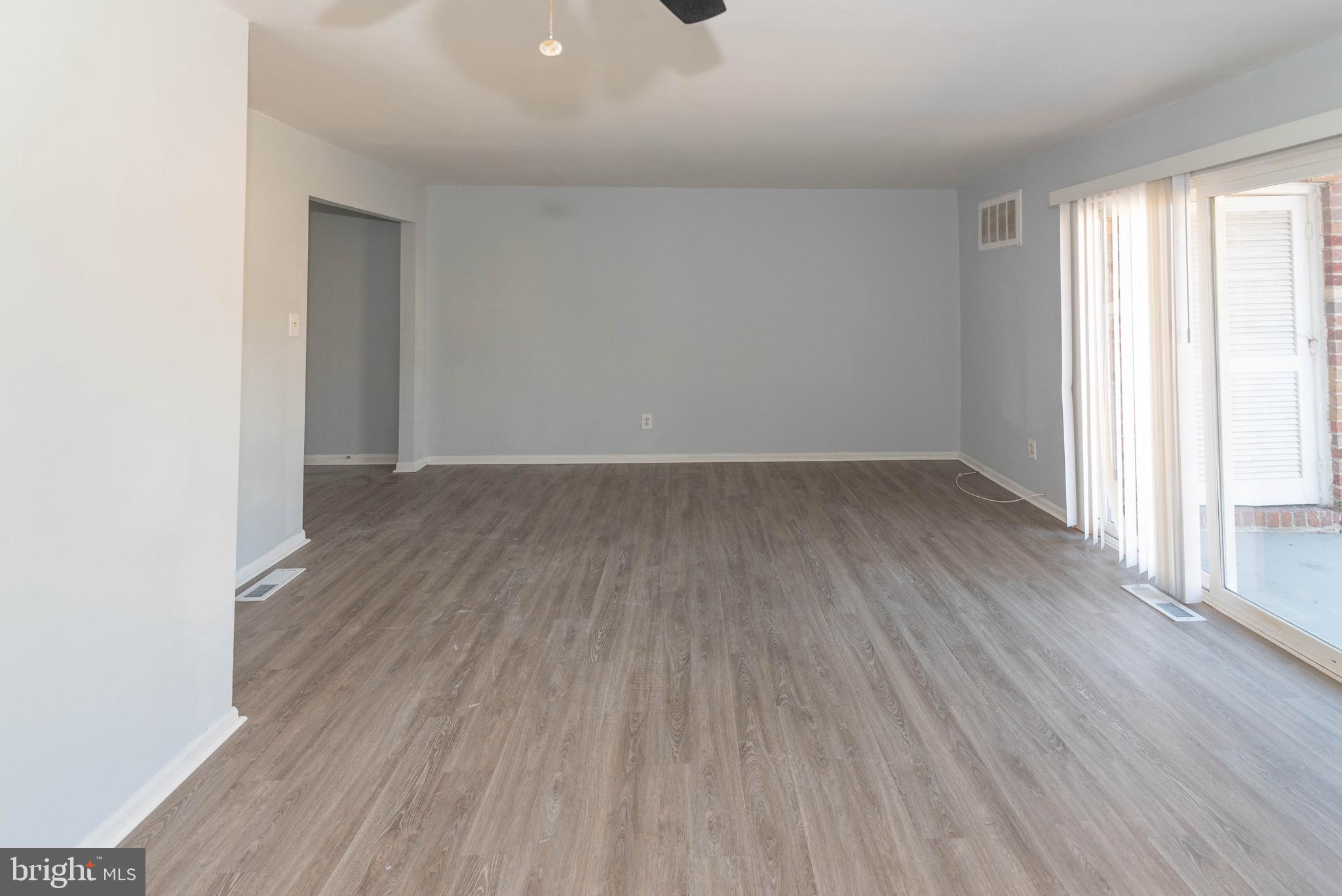 3712 Mayberry Avenue, Unit E Baltimore, MD 21206 - Photo 3 of 22 an empty room with wooden floor and windows