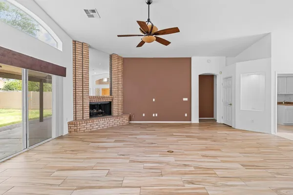 a view of an empty room with a window and a ceiling fan