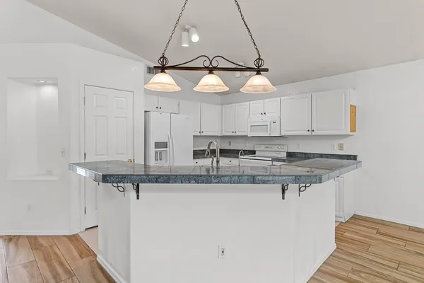 a kitchen with stainless steel appliances granite countertop a sink and a refrigerator