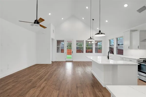 a large kitchen with lots of counter space wooden floor and appliances