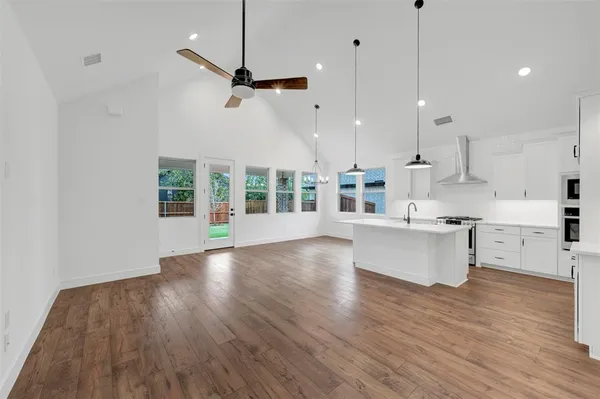 a kitchen with stainless steel appliances granite countertop a sink a stove and a large window