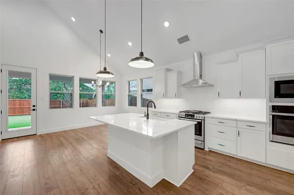 a kitchen with a stove a sink and a refrigerator
