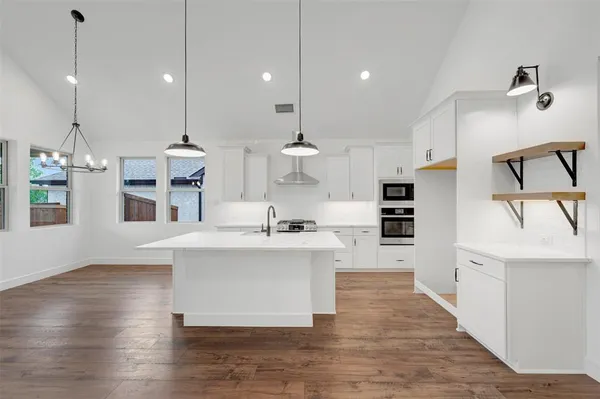 a kitchen with kitchen island stainless steel appliances a sink and cabinets