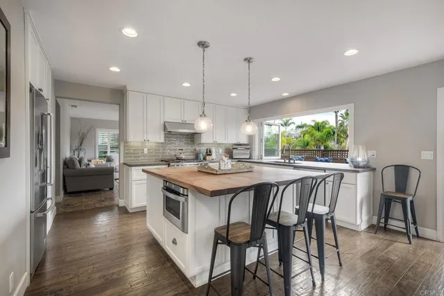 a kitchen with kitchen island a large counter top space a sink stainless steel appliances and cabinets