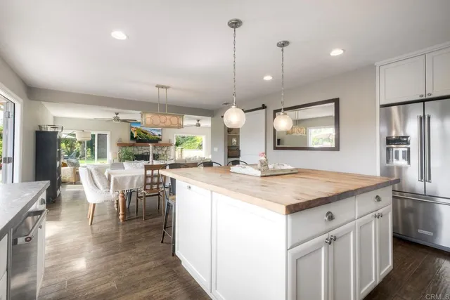 a kitchen with kitchen island a counter top space a sink stainless steel appliances and cabinets