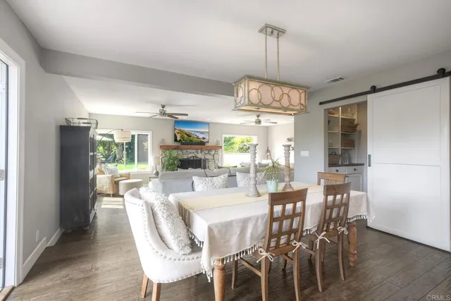 a dining room with furniture a chandelier and wooden floor