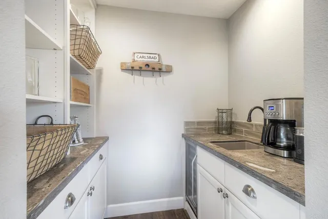 a kitchen with a sink and a stove with wooden floor