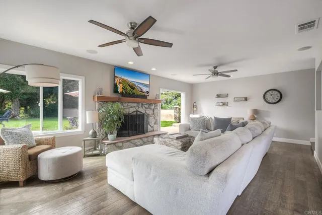 a living room with furniture a fireplace and a large window