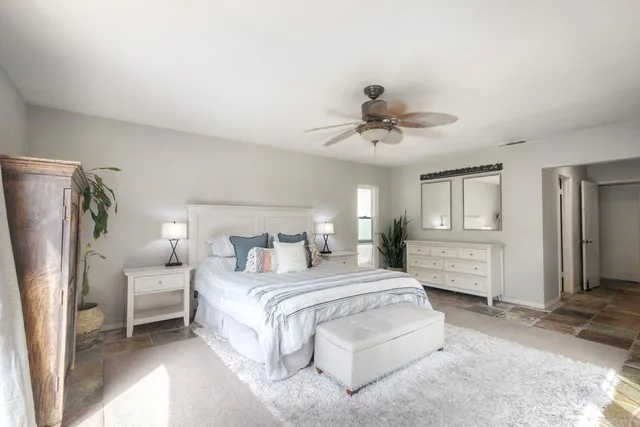 a spacious bedroom with a bed and a chandelier