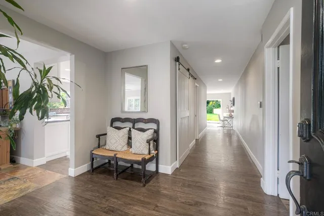 a view of a hallway with wooden floor and a potted plant