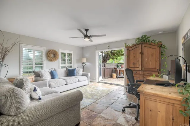 a living room with furniture a large window and a chandelier