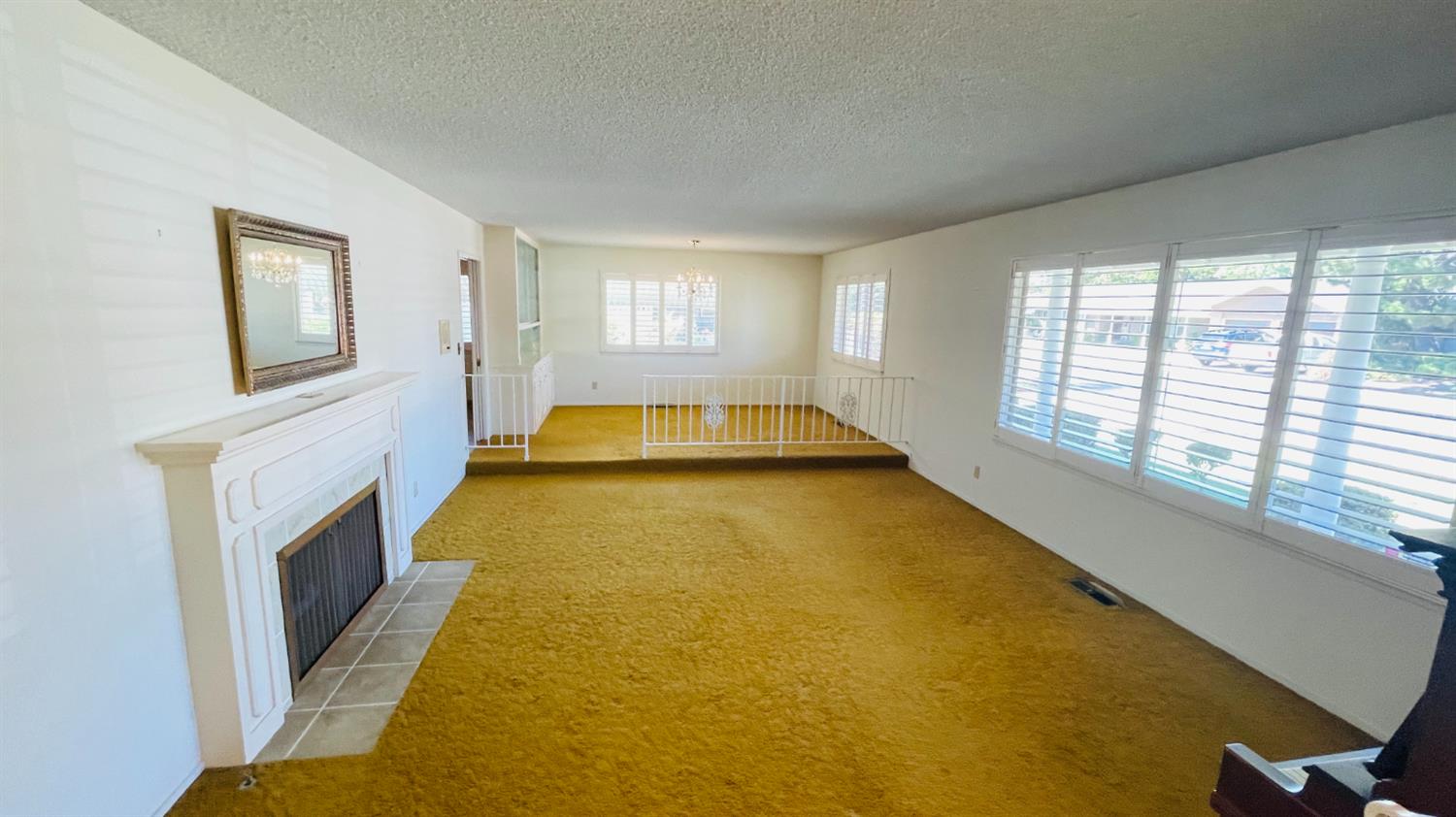 712 Leytonstone Avenue Modesto, CA 95355 - Photo 5 of 32 Step-down formal living room with fireplace and plantation shutters.