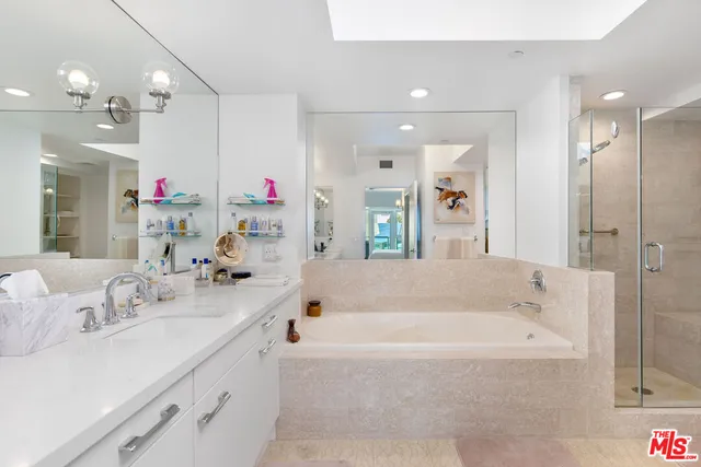 a bathroom with a tub a double vanity sink and a mirror