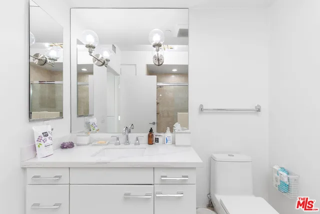 a bathroom with a sink vanity mirror and toilet