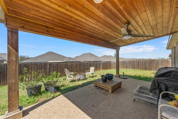 a roof deck with table and chairs and potted plants