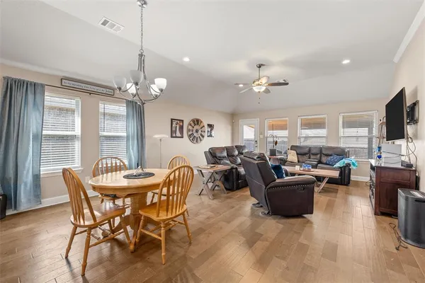 a view of a livingroom with furniture a chandelier and wooden floor