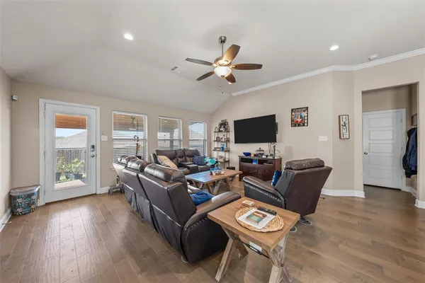 a living room with furniture a flat screen tv and a large window