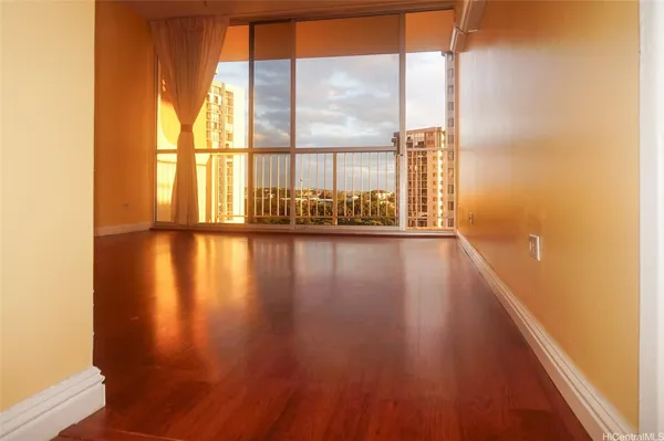 a view of empty room with wooden floor and fan
