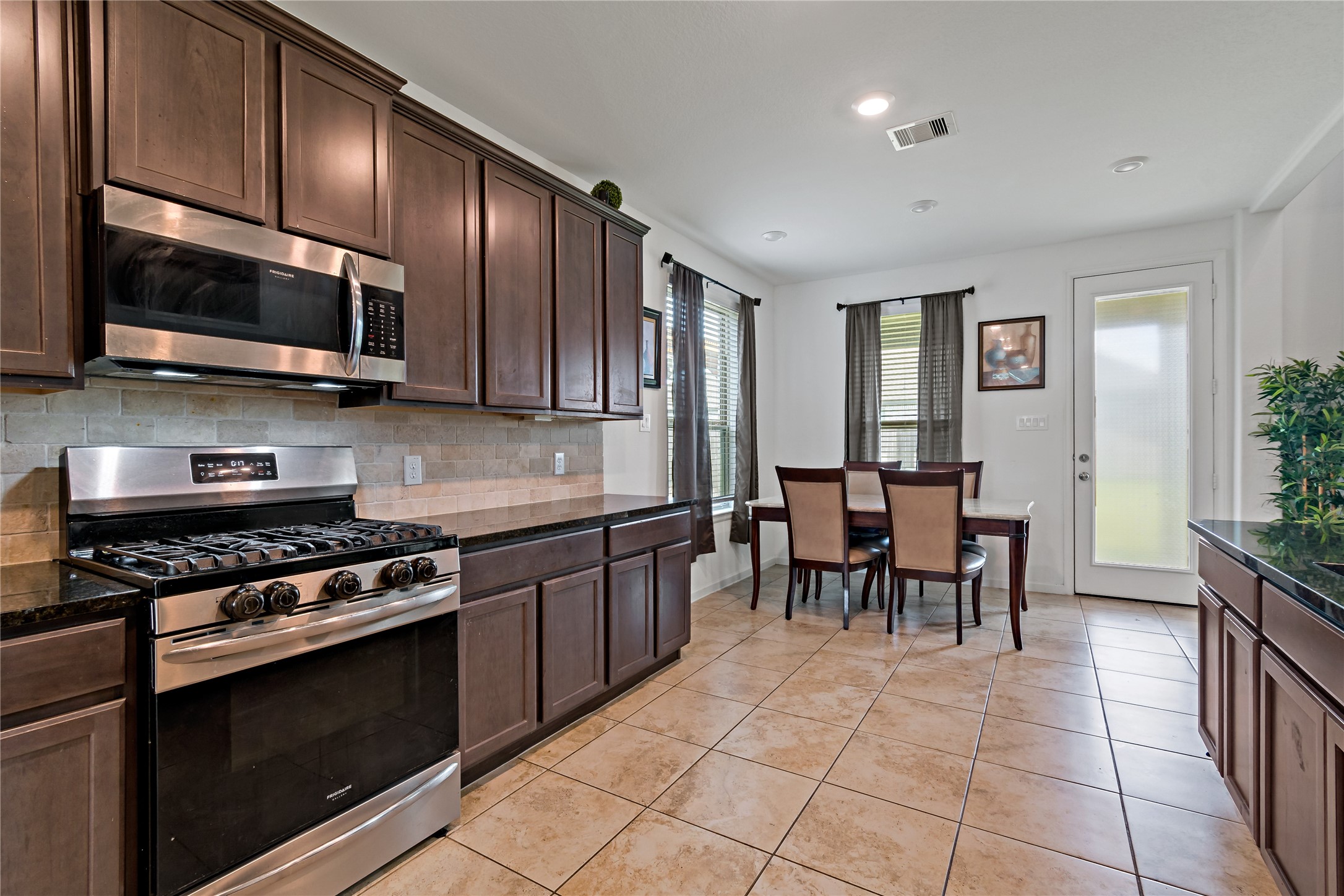 14010 Hartford Heights Way Rosharon, TX 77583 - Photo 6 of 30 a kitchen with stainless steel appliances granite countertop wooden cabinets a stove top oven a sink and dishwasher