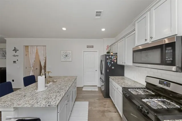 a kitchen with stainless steel appliances granite countertop a stove and a microwave
