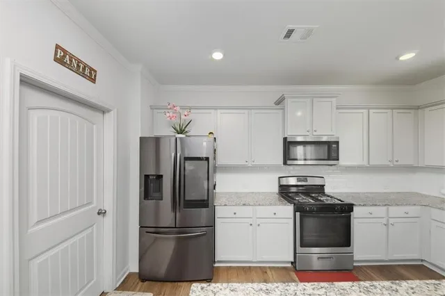 a kitchen with stainless steel appliances and refrigerator