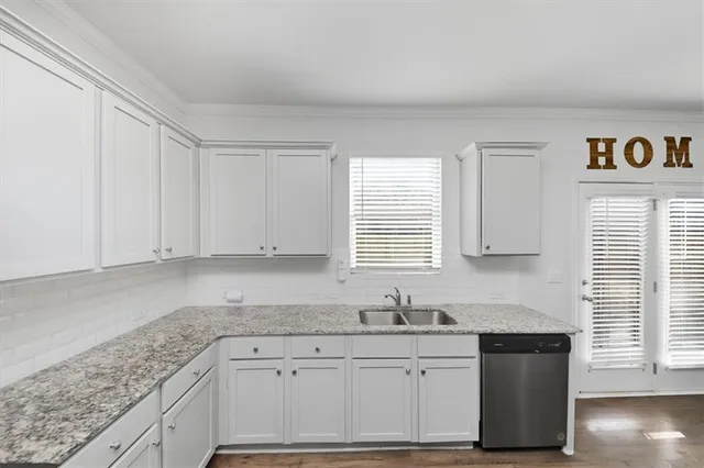 a kitchen with granite countertop a sink cabinets and window