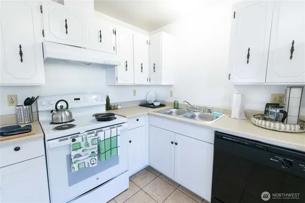 a kitchen with stainless steel appliances granite countertop a sink a stove and cabinets