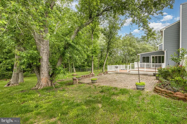 a view of a house with a big yard and large trees