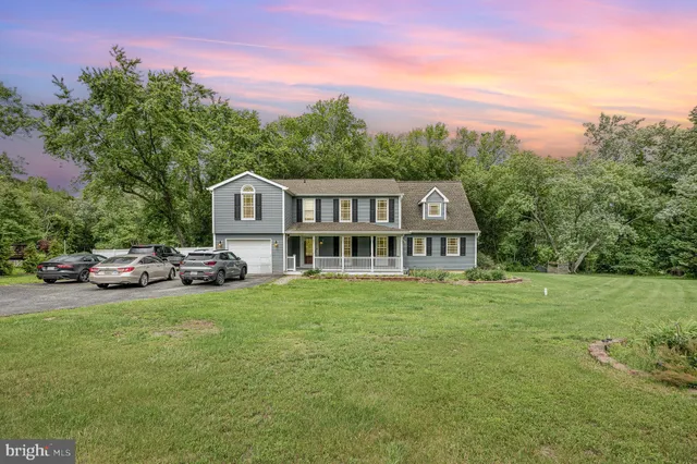 a view of a house with a garden and sitting area