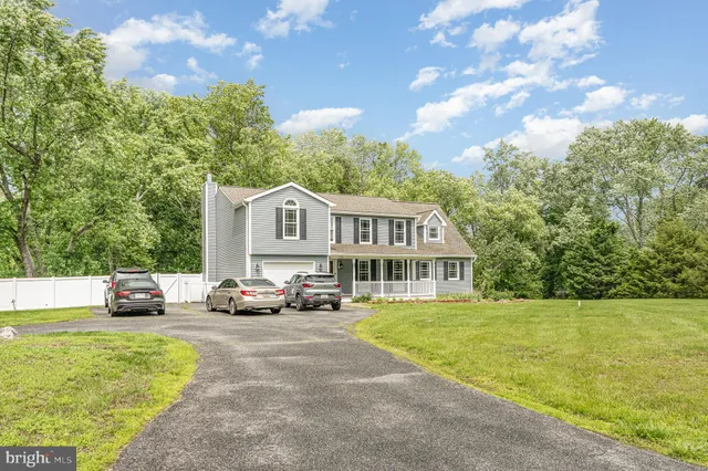 a view of a house with a big yard and large trees