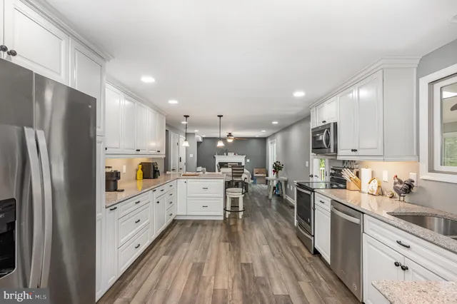 a kitchen with white cabinets and sink
