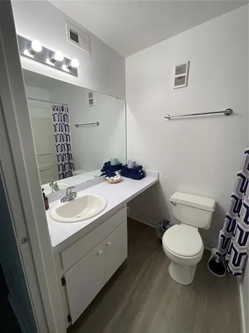 a bathroom with a sink a toilet a mirror and shower