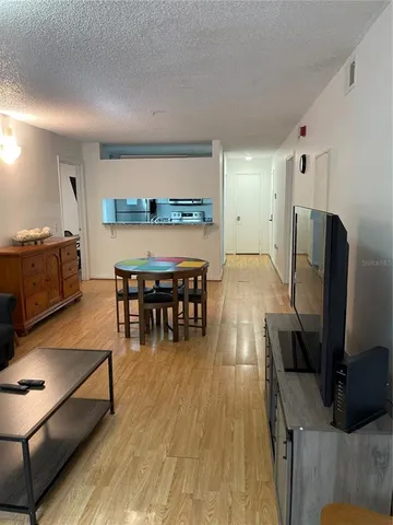 a living room with furniture a wooden floor and a flat screen tv
