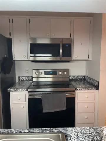 a kitchen with stainless steel appliances granite countertop a stove and a microwave