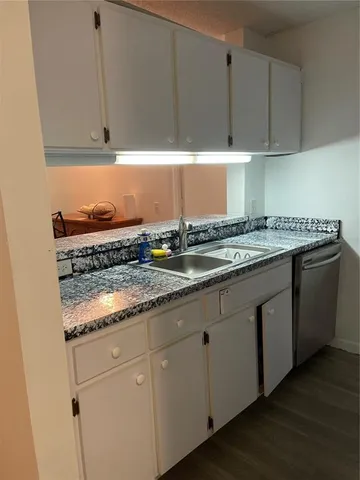 a kitchen with granite countertop cabinets sink and dishwasher