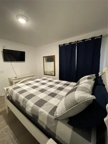 a bedroom with a bed and a flat screen tv