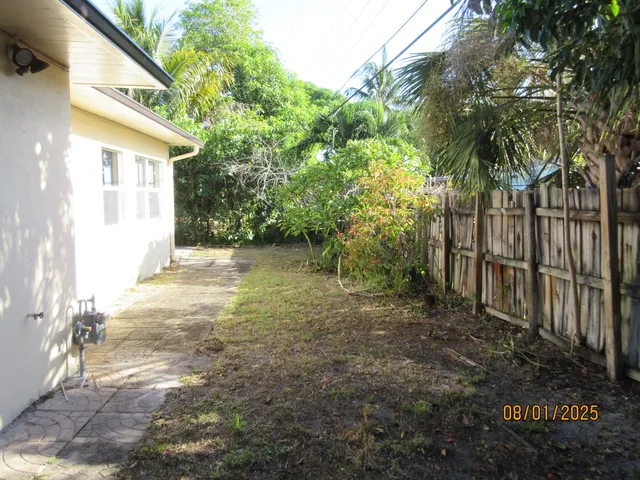 a view of a yard with plants and trees