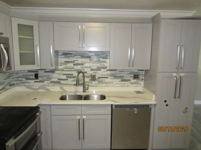 a kitchen with stainless steel appliances granite countertop a sink and cabinets