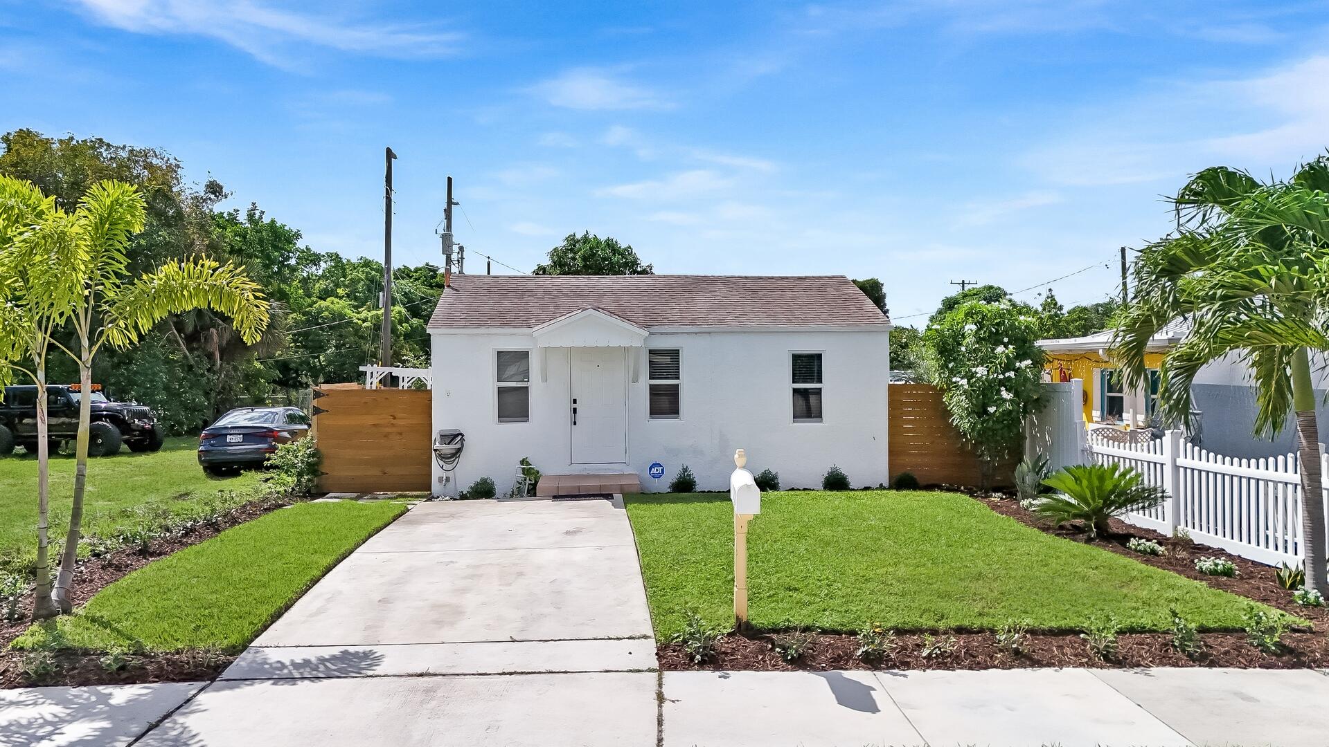 a front view of a house with a yard and potted plants